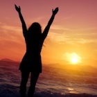 Resilient Woman at sunset with arms extended